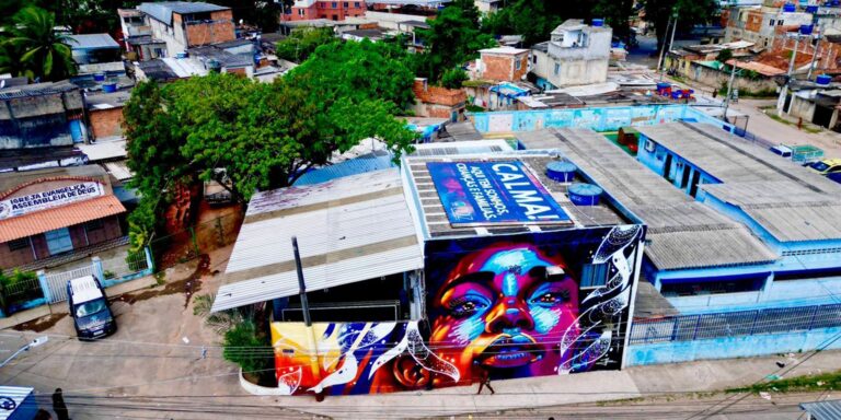 Telhado na Cidade de Deus diz: "Aqui tem crianças, sonhos e famílias"