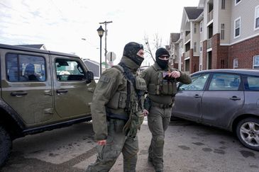 Homeland Security Investigations (HSI) agents stand next to their vehicle after stopping while conducting operations, following the fatal shooting of Renee Nicole Good by a U.S. Immigration and Customs Enforcement (ICE) agent, in a neighborhood in south Minneapolis, Minnesota, U.S., January 12, 2026. REUTERS/Seth Herald